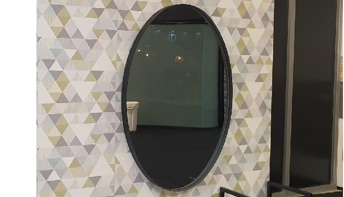 Oval mirror in a metal frame emphasize the style of the interior. The metal frame of the mirror is a...