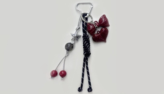 A keyring with ribbon and heart charms, adding a sweet and elegant touch. Perfect as an accent for k...