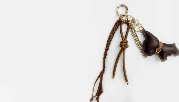 A cute keyring featuring a dog-shaped charm with leather straps and decorative accents. Perfect for ...