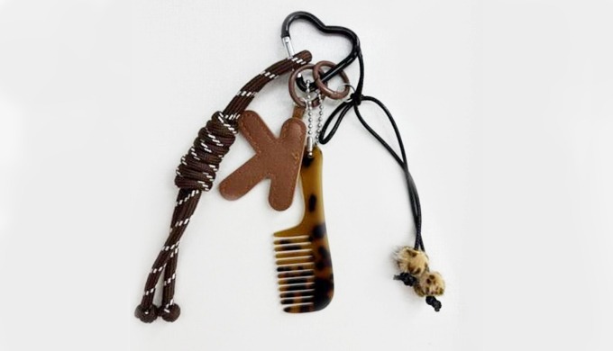 A stylish keyring featuring alphabet letters with assorted charms such as hearts, comb, and shoes. P...