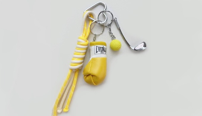 A unique keyring combining sports and retro charms such as boxing gloves, golf clubs, balls, and cas...