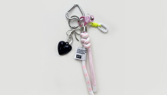 A chic keyring with heart and ribbon accents, blending black and pink for a lovely yet stylish look....