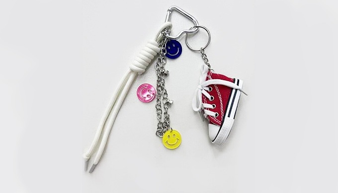 A playful sneaker-shaped charm keyring with a carabiner and strap, perfect for attaching to bags or ...