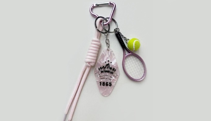 Each keyring highlights tennis, golf, or ping-pong with miniature rackets and balls. A playful acces...