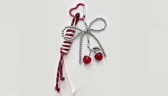 A refreshing cherry-shaped charm keyring with a carabiner and strap, perfect for attaching to bags o...