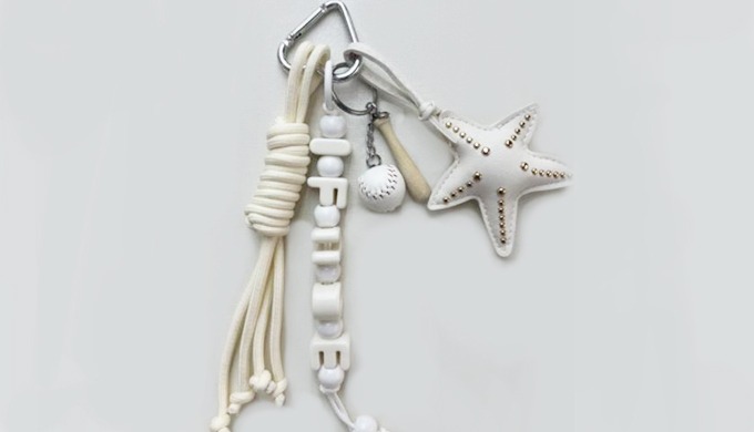 A keyring featuring a star-shaped charm with a carabiner and strap, perfect for attaching to bags or...