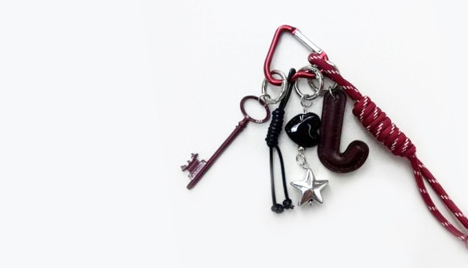 A unique keyring featuring alphabet letters with assorted charms such as keys, stars, and Eiffel Tow...