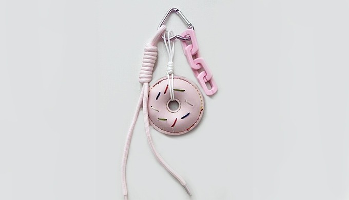 A playful donut-shaped charm keyring with a carabiner and strap, perfect for attaching to bags or ke...