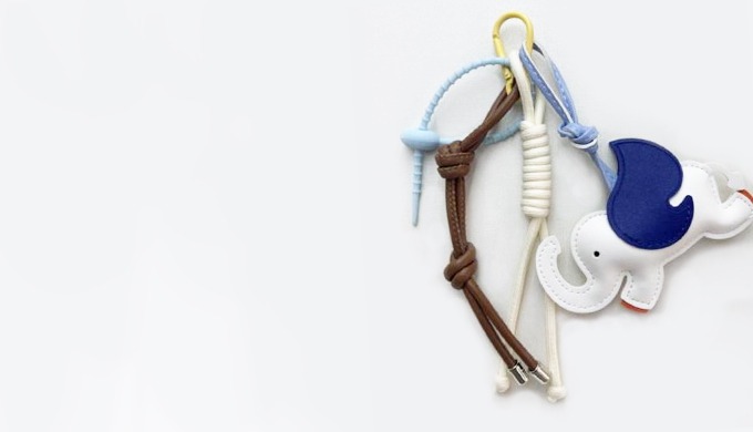 A cute elephant-shaped keyring with wing details, accented by colorful beads and ribbon charms. It a...