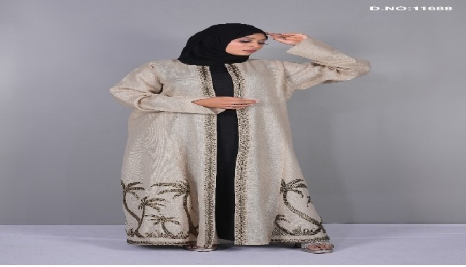Graceful beige shrug with detailed palm tree embroidery along the front and hem, designed to layer e...