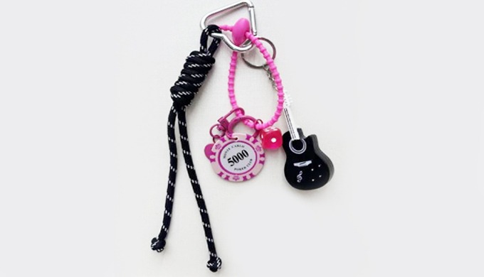 A trendy keyring featuring music-inspired charms such as guitar, headphones, and cassette tape. Perf...