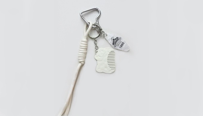 A practical keyring featuring a teddy bear comb charm, complete with a carabiner and strap for easy ...