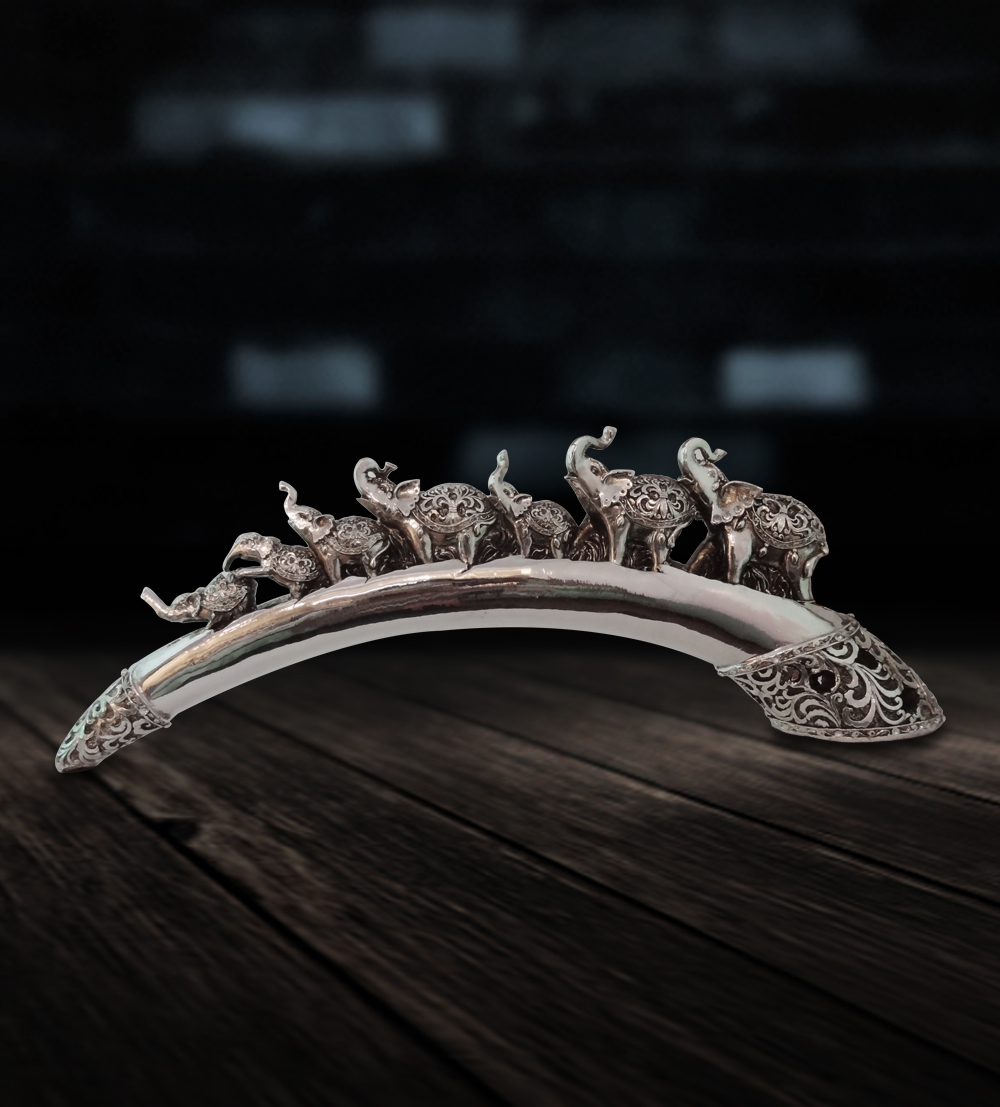 A master showpiece in the form of 7 elephants on a curved bridge, with designs made in silver redefi...
